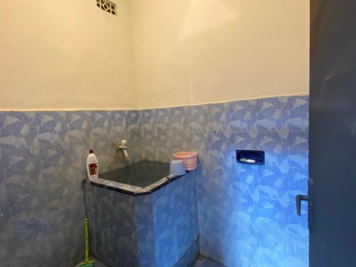 une salle de bain avec un mur carrelé bleu dans l'établissement La Via Living, à Sukobumi
