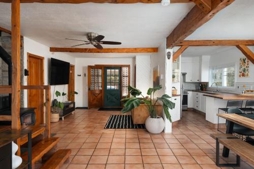 a living room with a ceiling fan and a kitchen at Le Selby in Dunham