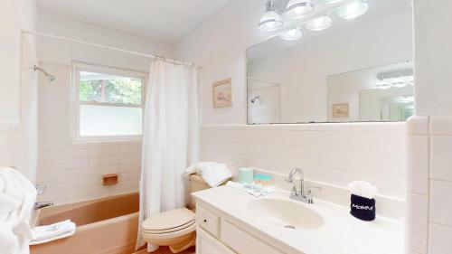 a bathroom with a sink and a toilet and a mirror at Reflection in Jekyll Island
