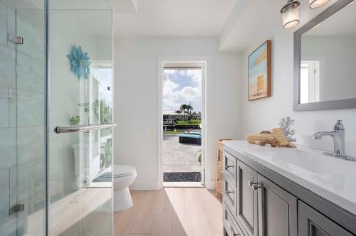 Un baño con lavabo, inodoro y espejo. en Lovers Key - Waterfront Stunner, Walk to Town!, en Cabo Coral