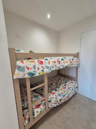 a bunk bed in a room with a bedsheet at Cozy studio proche plages et gare in Sanary-sur-Mer