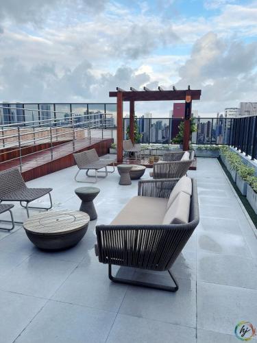 a patio with chairs and tables on a roof at Compact Time 1402 in Tambaú
