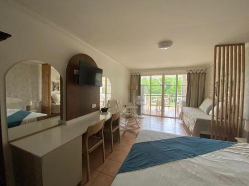 a bedroom with a bed and a desk with a mirror at Studio de rêve dans un village de vacances - Entièrement rénové 2025 - Clim rénovée 2025 in Sainte-Luce