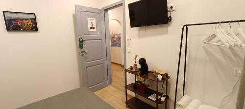 a hallway with a door and a television on a wall at Guest House Morais in Sintra