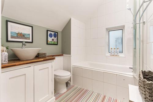 a bathroom with a tub and a toilet and a sink at Sea Croft in Worthing