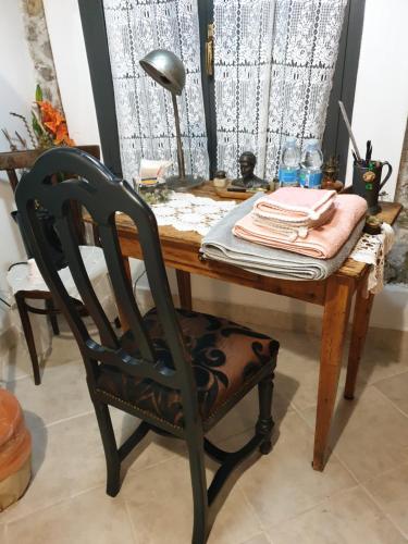 een houten tafel met een stoel en een bureau met een lamp bij Creativ hause in San Giuliano Terme