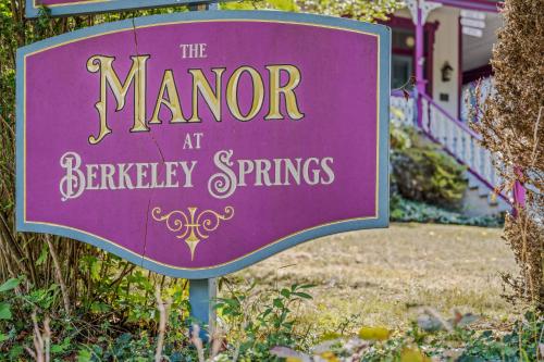 a purple sign for the manor at battery springs at The Manor - Historic Mansion, Wifi, Covered Porch, Screen Porch, King Bed, Walk to Spas, Shops & Restaurants in Berkeley Springs
