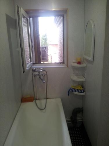 a bathroom with a bath tub with a window at Квартира on Vlasova 23 in Pyatigorsk