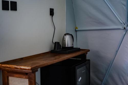 uma máquina de café sentada em cima de um balcão num quarto em نيوم العلا em Al Ula