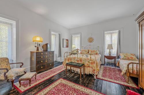 a bedroom with a bed and a table and chairs at The Manor - Historic Mansion, Wifi, Covered Porch, Screen Porch, King Bed, Walk to Spas, Shops & Restaurants in Berkeley Springs