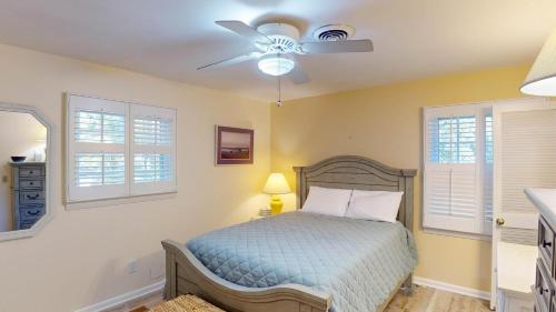 a bedroom with a bed and a ceiling fan at Beachbreak in Jekyll Island