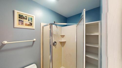 a bathroom with a shower with a toilet and blue walls at Beachbreak in Jekyll Island