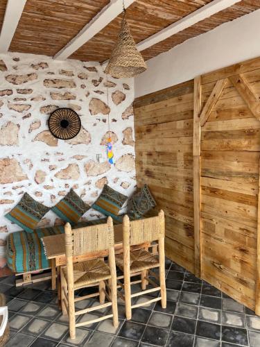 ein Zimmer mit Rattanstühlen und einer Steinwand in der Unterkunft Suite privée vue sur le océan in Wassane