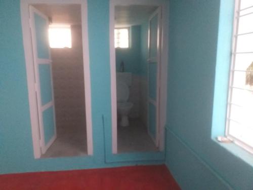 La salle de bains est pourvue de toilettes et de 2 miroirs. dans l'établissement Allô Gite, à Pondichéry