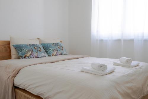 ein Bett mit zwei Handtüchern darauf in der Unterkunft LALA & DAUGHTERS Apartment in Vrnjačka Banja
