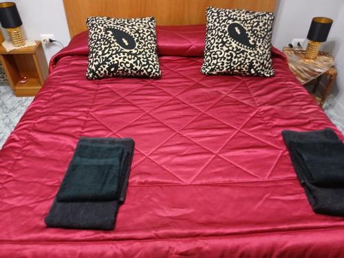 Una cama roja con dos almohadas encima. en Dream of Eden, en Roma