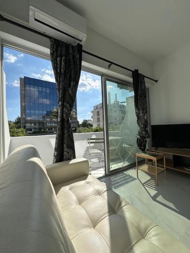 a living room with a couch and a large window at Seaside Studio in Limassol