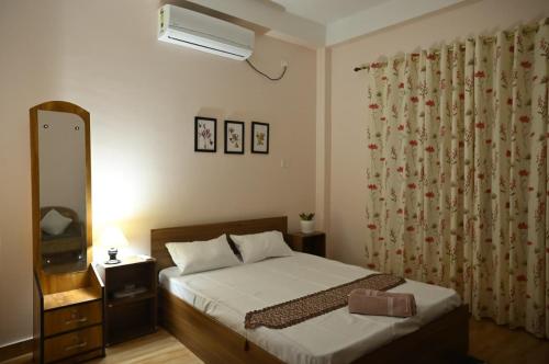 JorhatUptown Escape的带床、梳妆台和镜子的卧室