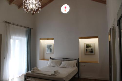 a bedroom with a bed and a clock on the wall at Aenaon Corfu Luxury Apartments #04 - Aphrodite Apartment in Ýpsos