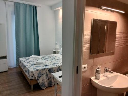 a small bathroom with a bed and a sink at D&Dhome in Mola di Bari