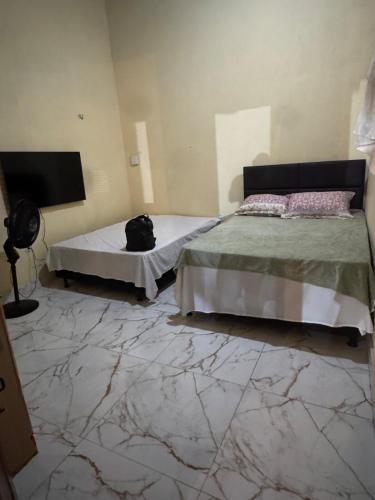 a bedroom with two beds and a cat laying on the floor at Espaço para Eventos e Temporadas em in Paracuru