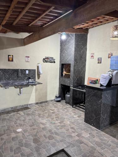 a bathroom with a stone floor and a fireplace at Espaço para Eventos e Temporadas em in Paracuru
