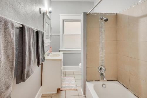 a bathroom with a tub and a sink and a shower at 1 Mi to Lake Michigan! Urban Racine Apartment in Racine