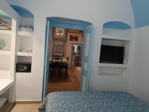a bedroom with a room with a bed and a tv at Odysseas Traditional house in Mesaria