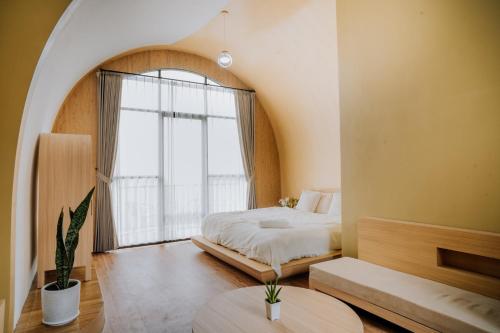 um quarto com uma cama e uma janela grande em cithara villa em Kejajar