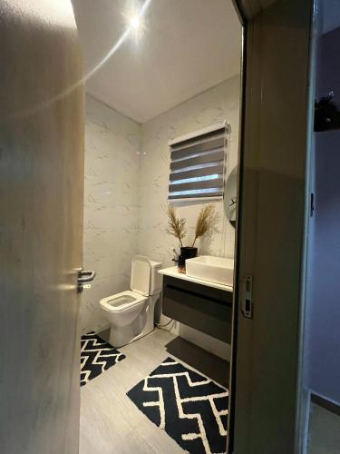 a bathroom with a toilet and a sink at Terra Verte Court in Accra