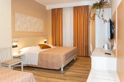 ein Hotelzimmer mit einem Bett, einem Schreibtisch und einem Zimmer in der Unterkunft Lepanto Central in Messina