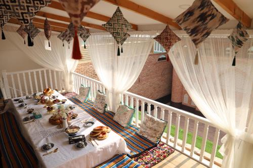 une table avec de la nourriture dessus dans une pièce dans l'établissement Movarounnahr - Гостевой дом, à Margilan