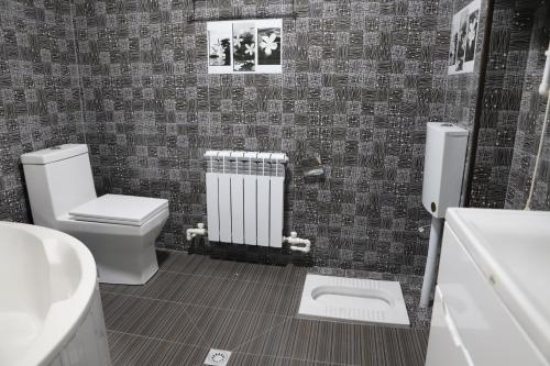 une salle de bains avec des toilettes et un radiateur dans l'établissement Movarounnahr - Гостевой дом, à Margilan