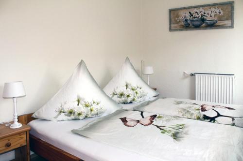 zwei Kissen auf einem Bett mit Schmetterlingen drauf in der Unterkunft Pension Nordsee in Norddeich