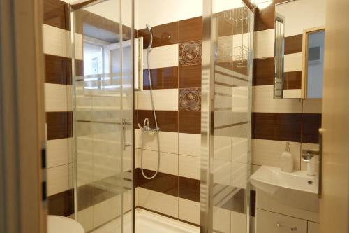 a bathroom with a shower and a toilet and a sink at Hotel Mina in Craiova