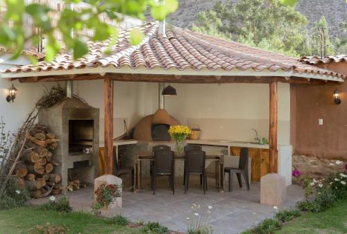a pavilion with a kitchen and a table and chairs at Casa Julia in Huayllabamba