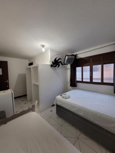 ein Schlafzimmer mit einem Bett und einem Fernseher in der Unterkunft Hotel Silveira in Guarapari