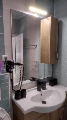 a bathroom with a sink and a shower and a mirror at Pearl XL in Pamporovo