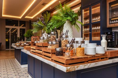 a buffet line in a restaurant with food at Hotel Kindermann Chapecó - Hotel Novo in Chapecó