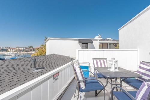 eine Terrasse mit Stühlen und einem Tisch auf dem Dach in der Unterkunft Updated 1Br Bayfront Cottage W Deck In Quiet Balboa Island By Beachview Rentals in Newport Beach
