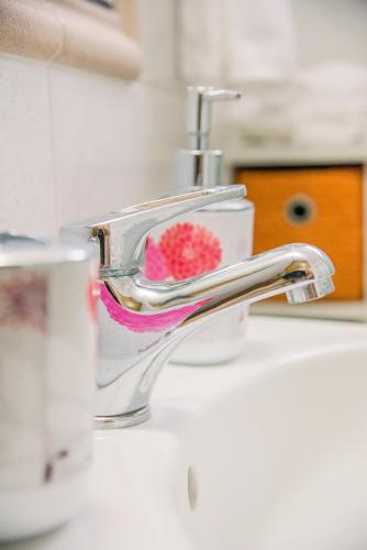 a bathroom sink with a faucet with a red sponge at Creta Sea View 2BR Maisonette by ΜΡS in Marathokefála