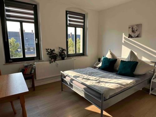 ein Schlafzimmer mit einem Bett und zwei Fenstern in der Unterkunft 1,5 Zimmer für 4 Personen auf 38qm Wohnfläche in Niederdorla