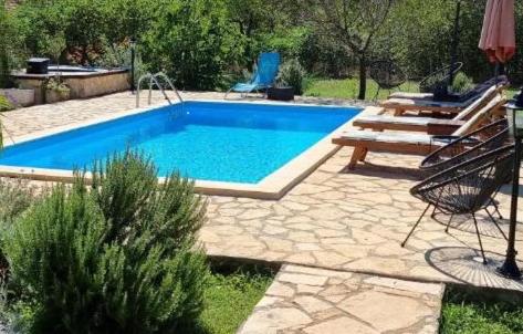 a swimming pool in a yard with a bench next to it at Family friendly holiday home "Ana" in Šibenik