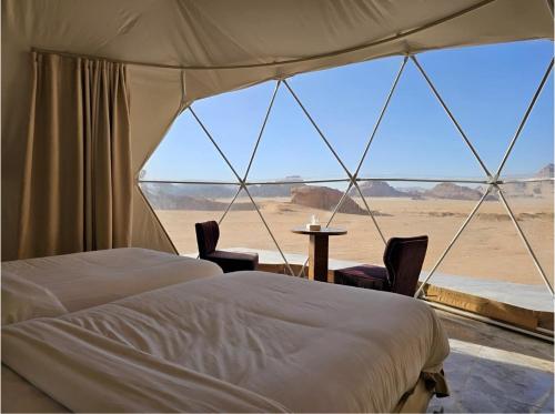 a bedroom with a view of the desert from a tent at MIRNA lUXURY CAMP in Wadi Rum