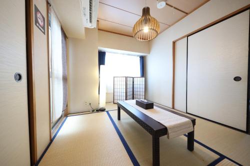 um quarto com um banco e uma grande janela em Duetoir 801 / Vacation STAY 7558 em Nagoya
