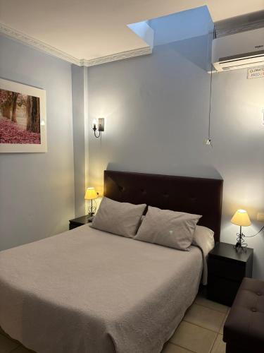 a bedroom with a bed with two night stands and two lamps at Hostal Cerezo 2 in Guadalupe