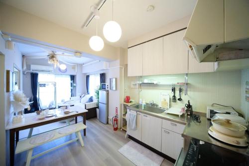 a kitchen with white cabinets and a counter top at Maison Etoile 706 / Vacation STAY 7561 in Nagoya