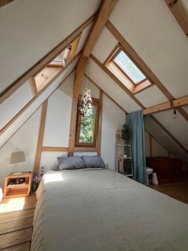 une chambre avec un grand lit dans un grenier dans l'établissement Cozy frame house in the wood, 