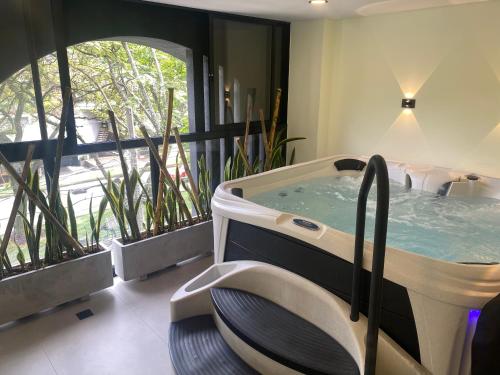 a hot tub in a room with windows at Hotel Ryo 74b Piso 7 Vip in Medellín
