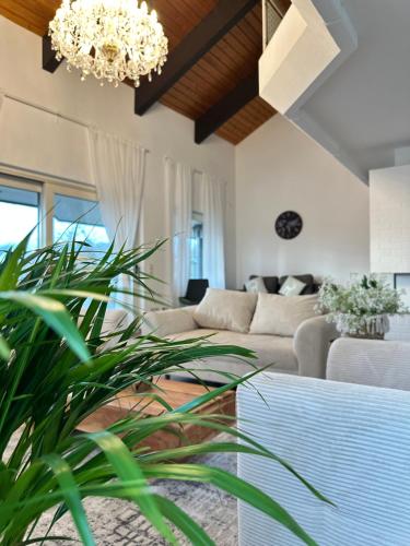 ein Wohnzimmer mit einer Couch und einem Kronleuchter in der Unterkunft Wunderschöne Familienvilla mit Schlossblick in Lahnstein